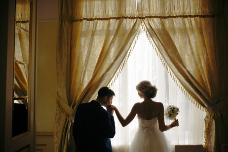 新娘和新郎站在前面的窗口