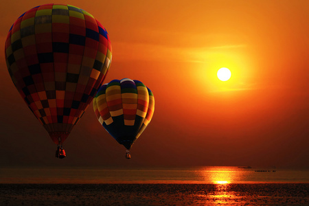 热气球在日出海滩上空。旅游概念