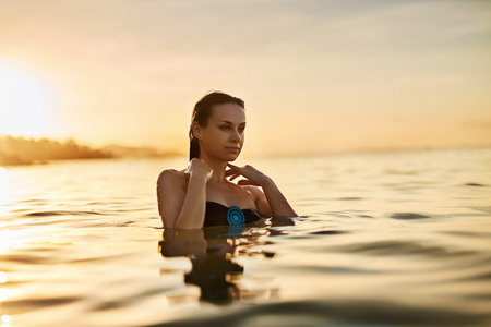 身体护理。 享受海上日落的女人。 健康的生活方式。 夏季