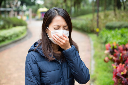 亚洲女人生病，戴着口罩