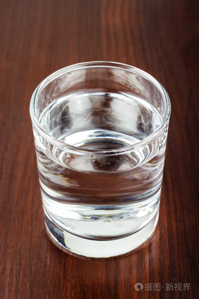 玻璃的透明纯净水木制的桌子上