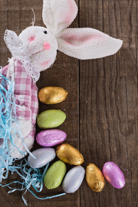 质朴的木制背景复活节兔子和巧克力蛋