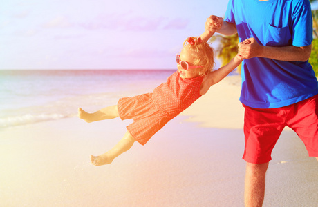 父亲和小女儿在海滩玩