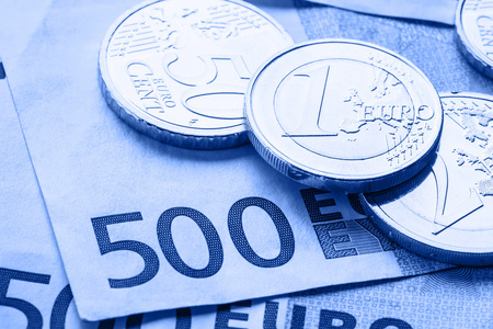 几个 500 欧元纸币和硬币是相邻的。财富的的象征照片。欧元硬币纸币的背景与堆栈上的平衡