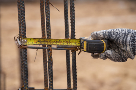 卷尺类施工在施工现场用卷尺测量钢杆照片