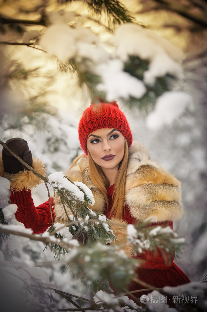 女人白雪覆盖的树木树枝下构成的金发女孩年轻女性与周围雪花在明亮