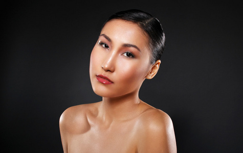 在黑色背景上有吸引力的亚洲女人皮肤护理图像