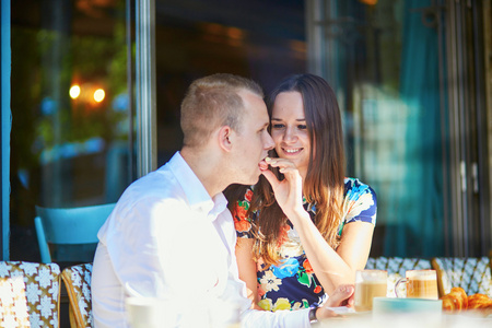年轻情侣在一个舒适的露天咖啡馆，在巴黎，法国