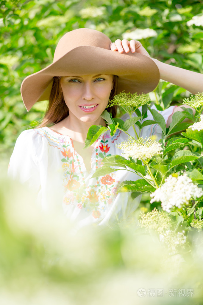 春季女人在绿色的花园里享受阳光明媚的日子