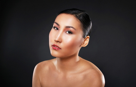 在黑色背景上有吸引力的亚洲女人皮肤护理图像