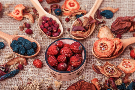 干燥的水果和浆果放在一个木碗里，在堆叠的背景特写镜头上