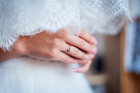 温柔美丽的新娘手上优雅的白色婚纱礼服特写