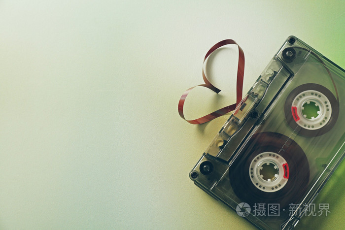 复古的音频盒式磁带在心绿色模糊背景上的形状