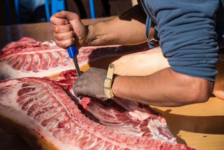 机架的猪肉屠夫手上鲜猪肉照片