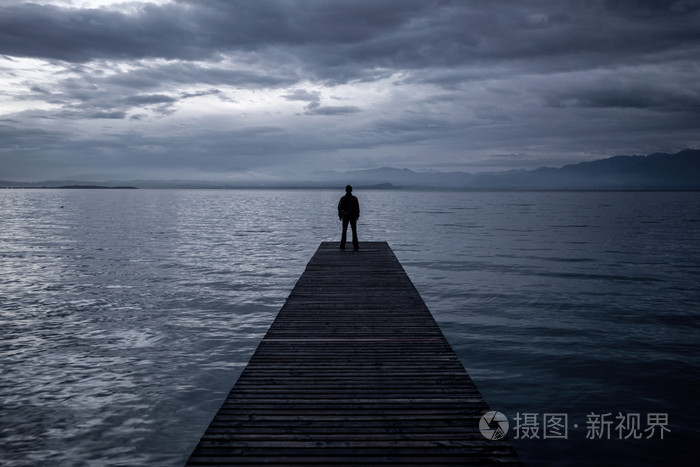 孤独的人站在码头上