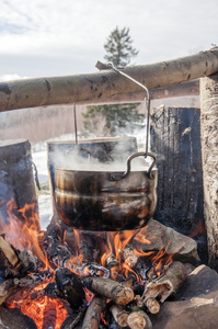 在现场条件下做饭，烧开水的壶在营火上野餐