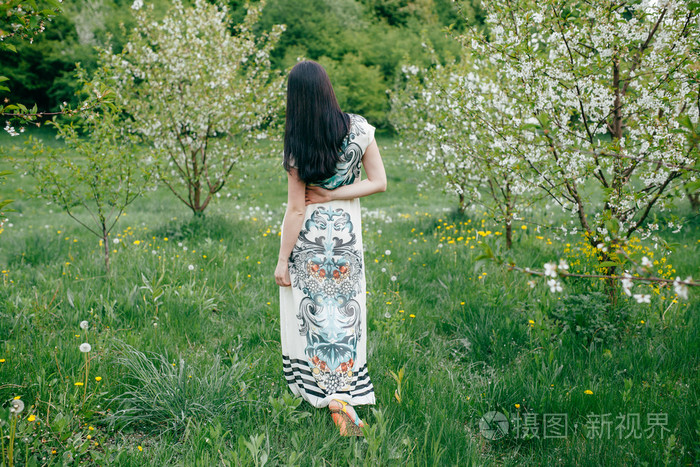 一个漂亮的樱桃果园春天步行女孩