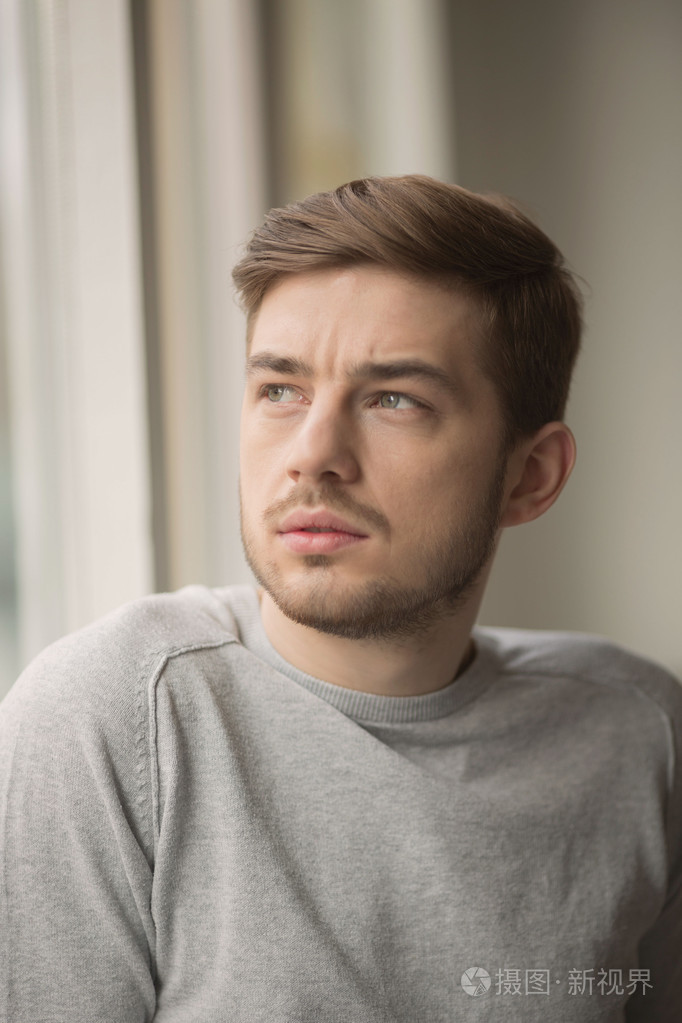 模糊背景下年轻有思想的英俊男子的肖像