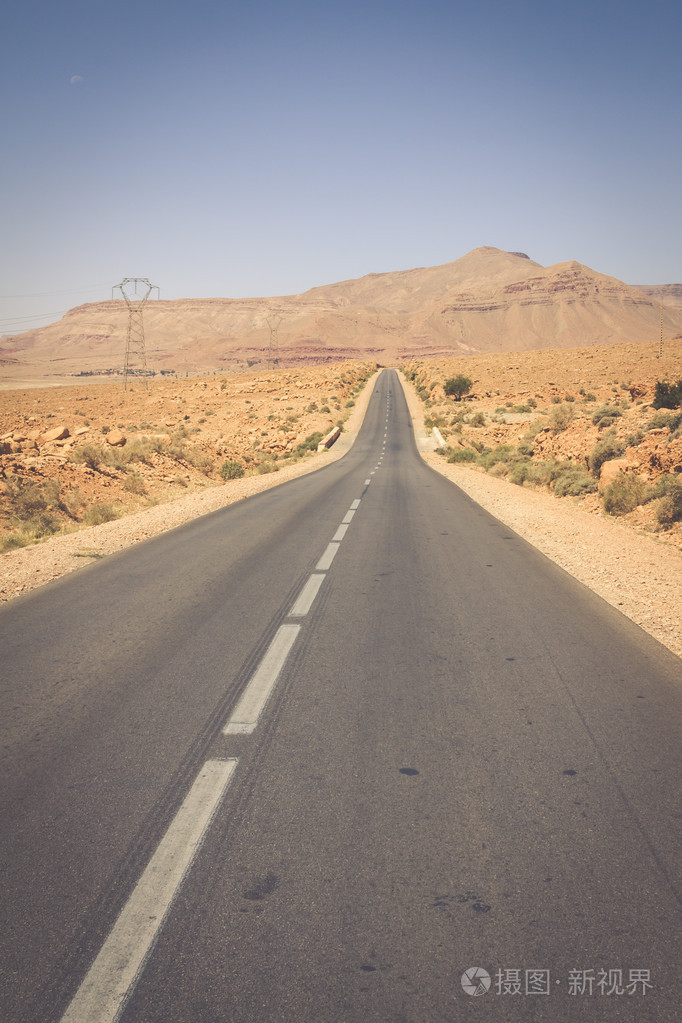 无尽的道路在撒哈拉沙漠与蓝蓝的天空摩洛哥非洲