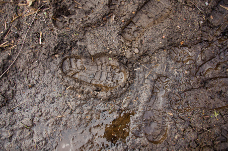 棕色道路上有脚印的泥土.背景照片纹理.