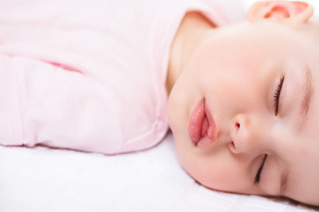可爱熟睡的婴儿，在白色和粉红色的西装