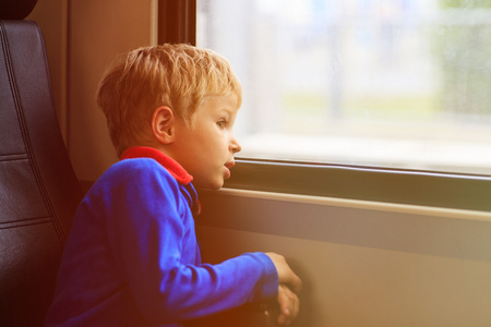 小男孩乘火车看着车窗外
