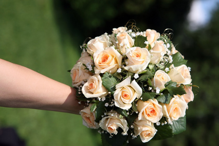 在新娘的手里的白玫瑰的美丽婚礼花束