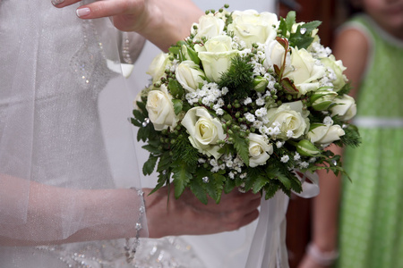在新娘的手里的白玫瑰的美丽婚礼花束