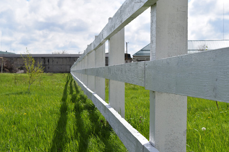 牧场周围白色的木制栅栏。 村子里的木栅栏。