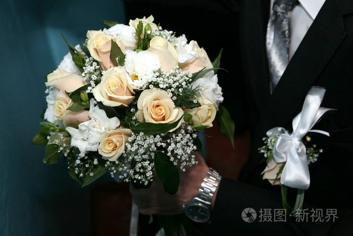 新郎抱着玫瑰婚礼花束