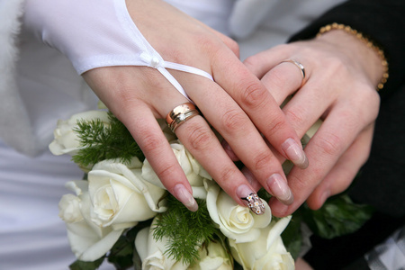 新娘和新郎在婚礼花束附近手中