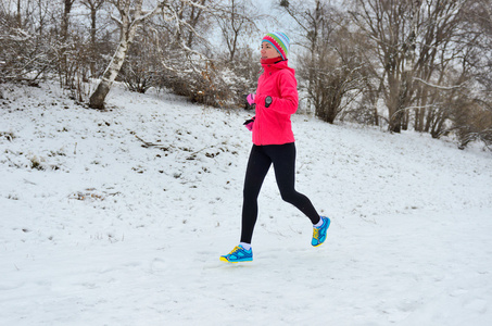 冬天在公园跑步 幸福的女人跑慢跑在雪 户外运动和健身概念