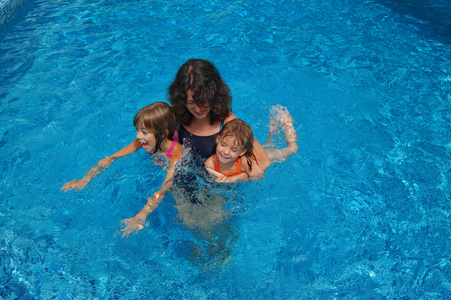 幸福的家庭，在暑假的时候，母亲和孩子们在游泳池里玩