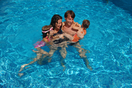 幸福的家庭，在放暑假在游泳池里玩
