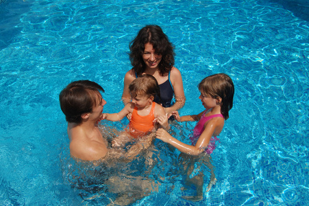 幸福的家庭，在放暑假在游泳池里玩