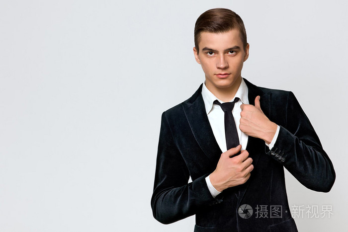 年轻人在一个时髦的西装,打领带,工作室