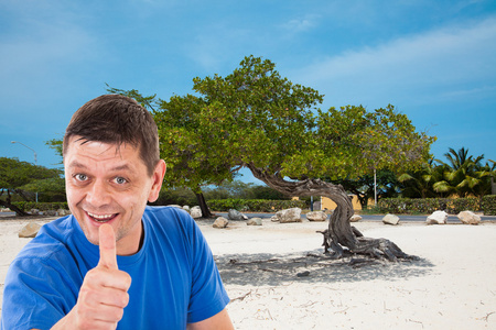 特立尼达湾海滩在阿鲁巴用拇指向上的人照片