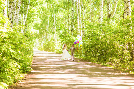 在公园里举行的气球一堆美丽的新娘。新娘和新郎与气球的夫妇。新婚夫妇用气球在户外