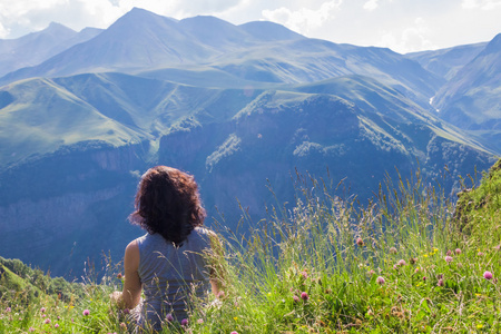 女人坐在一座山的顶部