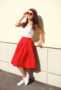 美丽的黑发女人，戴着太阳镜，红色裙子的 c