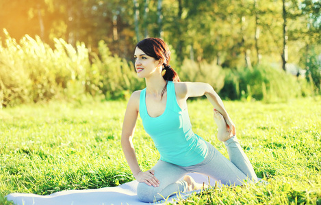 夏天阳光灿烂的日子草瑜伽锻炼的年轻女人