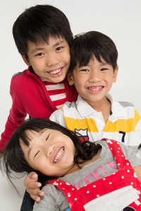亚洲家庭幸福拥抱在灰色的背景上