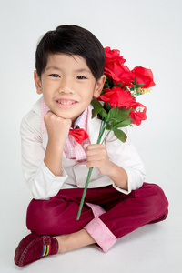 小亚洲男孩在老式西装与红玫瑰