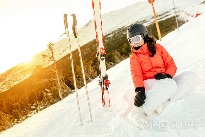 女人坐在雪，享受着从山上的景色的肖像