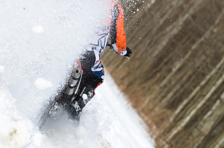 摩托车越野赛车手骑摩托车在深雪中的后视图