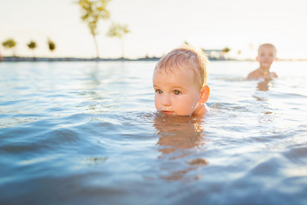 小男孩在阳光灿烂的夏天一天在水中游泳