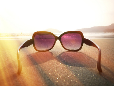 在滨海湾海滩沙子上太阳镜