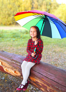 快乐微笑小女孩的孩子花伞在秋天