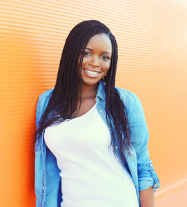 美丽的，快乐的，微笑的非洲女人，橙色的背