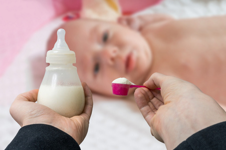 手捧瓶与通航为喂养的婴儿配方奶粉